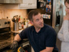 Appliance repair technician inspecting a potentially hazardous kitchen oven while speaking with a homeowner inside a suburban Marietta home kitchen.